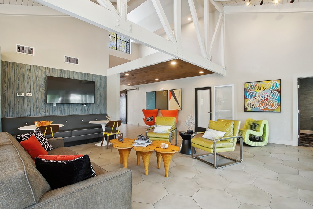 a living room with a couch and chairs and a television