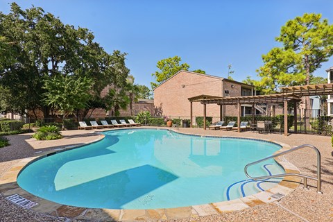A small pool with a metal railing and steps leading to it.