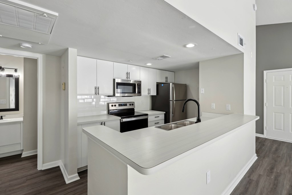 a kitchen with an island and a stove and a refrigerator