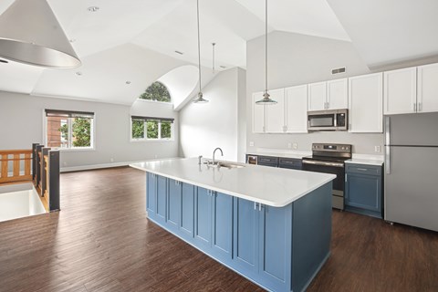 A kitchen with a white counter top and blue cabinets.