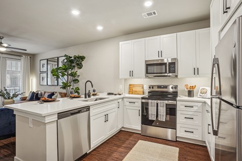 A modern kitchen with white cabinets and stainless steel appliances.