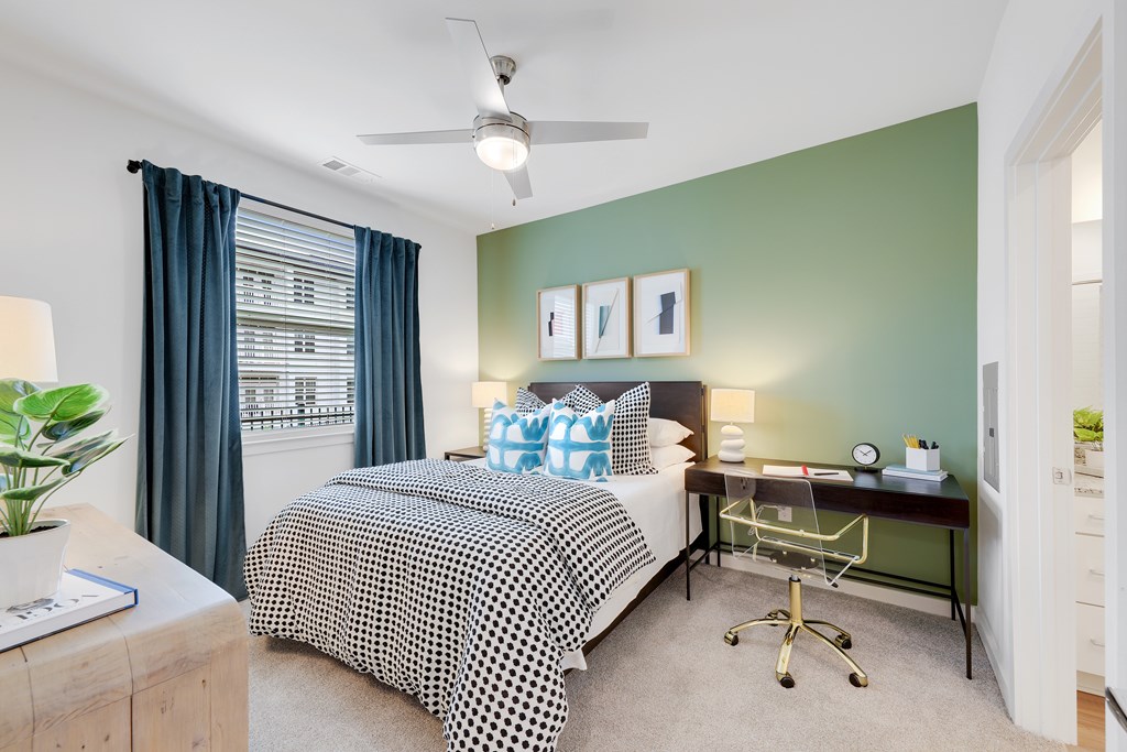 a bedroom with a bed and a desk and a window