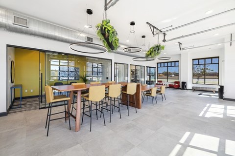 A modern dining room with a long table and chairs.