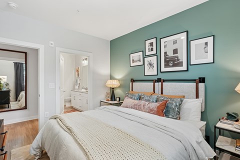 A bedroom with a large bed and pictures on the wall.