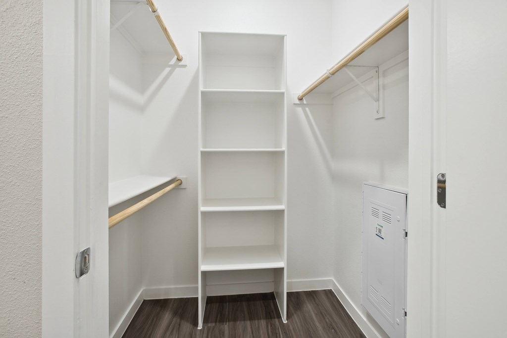 a closet in a small room with shelves and a white door