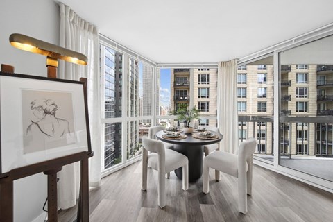 A dining room with a table set for two and a view of the city.