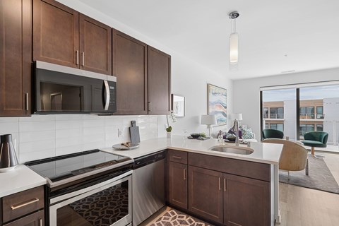 A modern kitchen with dark brown cabinets and white countertops.