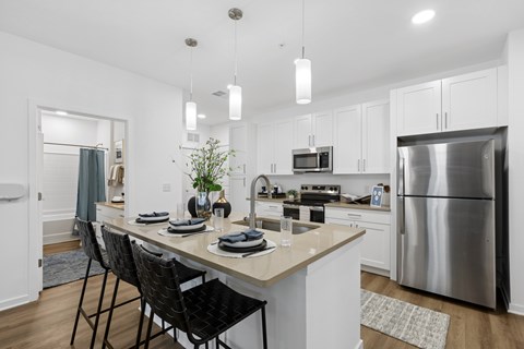 A modern kitchen with a dining table set for two.