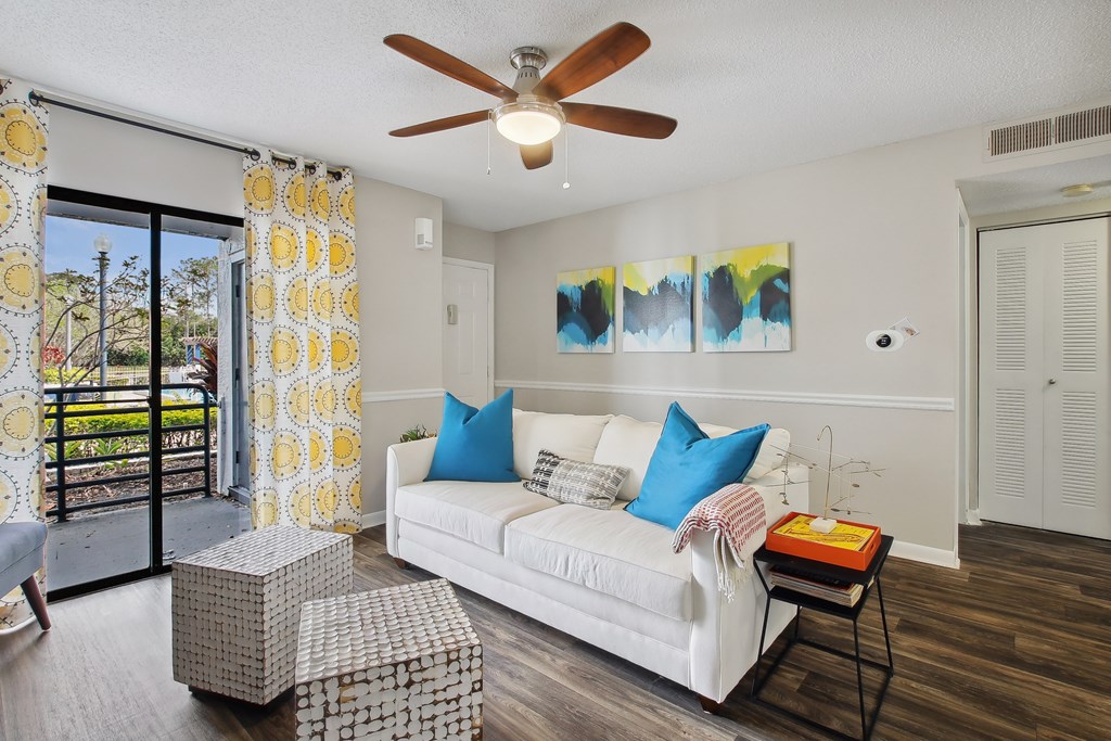 a living room with a white couch and a ceiling fan
