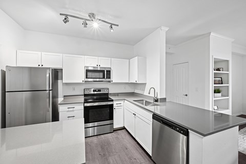 A modern kitchen with stainless steel appliances and white cabinetry.