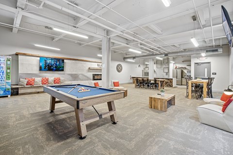 A room with a pool table and a TV mounted on the wall.
