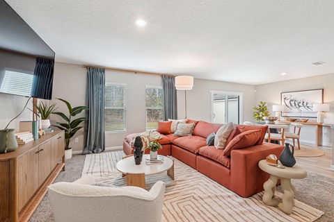A living room with a red couch and a white chair.