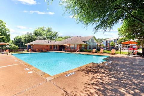 A large outdoor swimming pool with a building in the background.