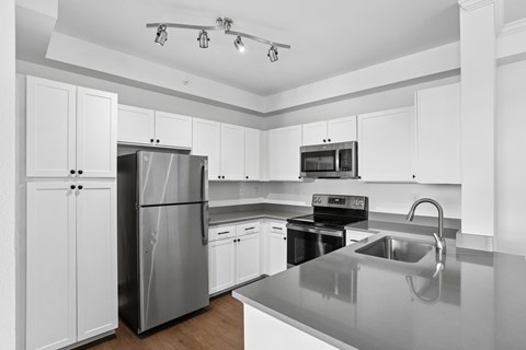 A modern kitchen with stainless steel appliances and white cabinets.