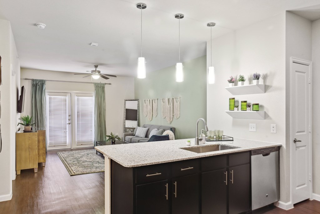 the view of a living room from a kitchen with a sink