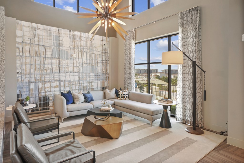 a living room with large windows and a chandelier
