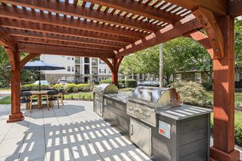 a covered patio with two grills and a wooden pavilion