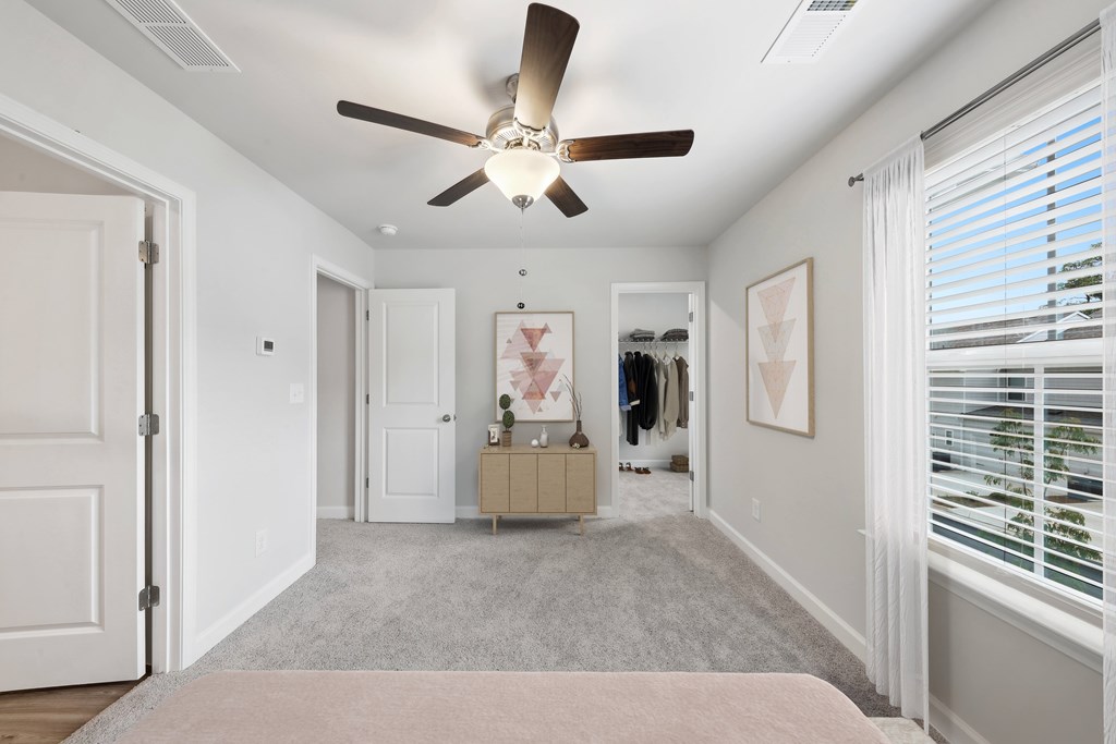 a bedroom with a ceiling fan and a closet