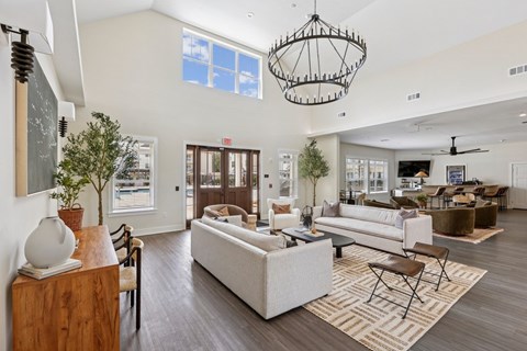 A spacious living room with a large sofa set and a chandelier.