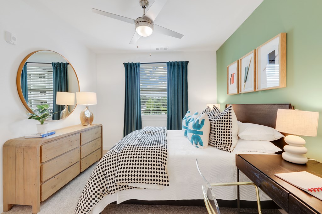 a bedroom with a bed and a dresser and a ceiling fan