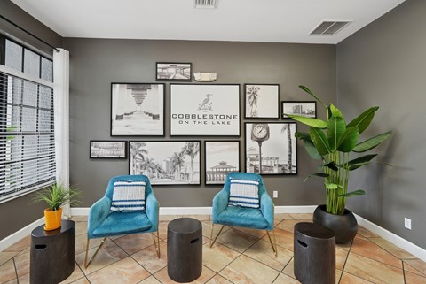 A living room with a blue chair and a plant.