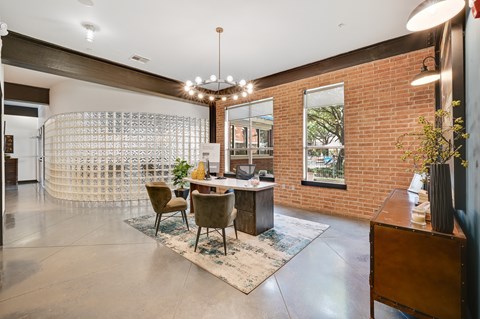 A room with a brick wall and a table with chairs.