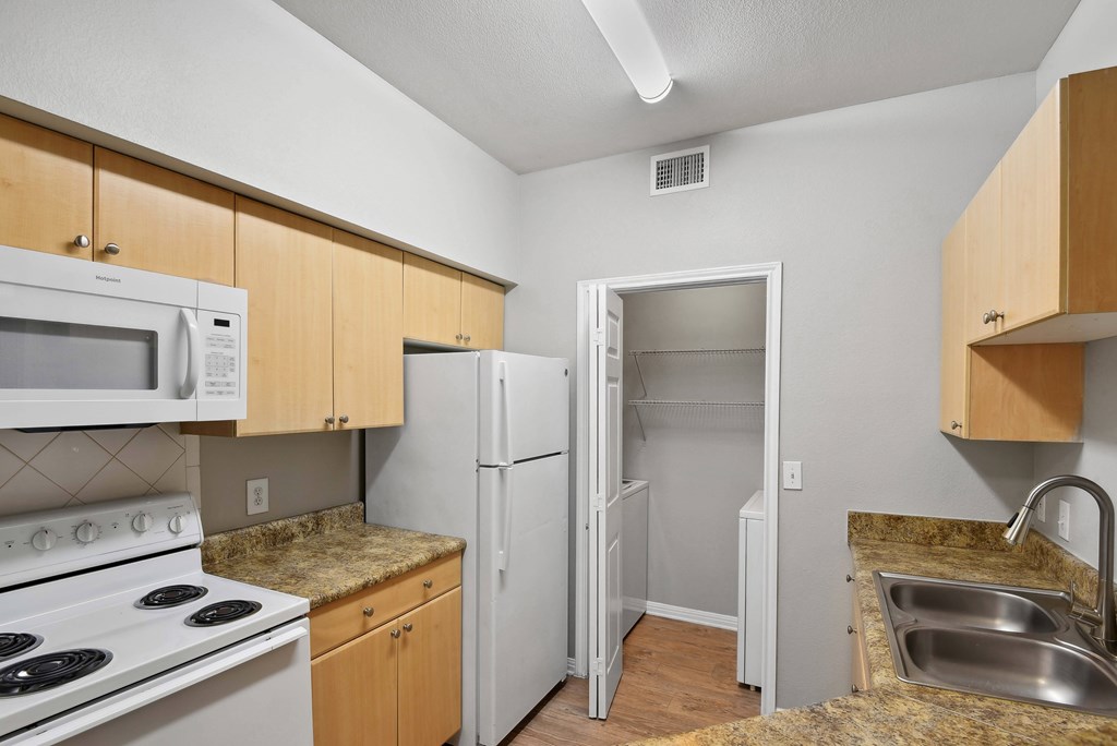 kitchen with appliances and hardwood like flooring