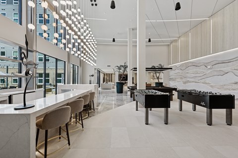 A modern interior with a long bar and pool tables.