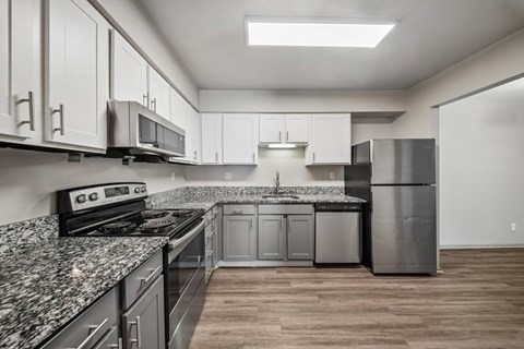 A kitchen with granite countertops and stainless steel appliances.
