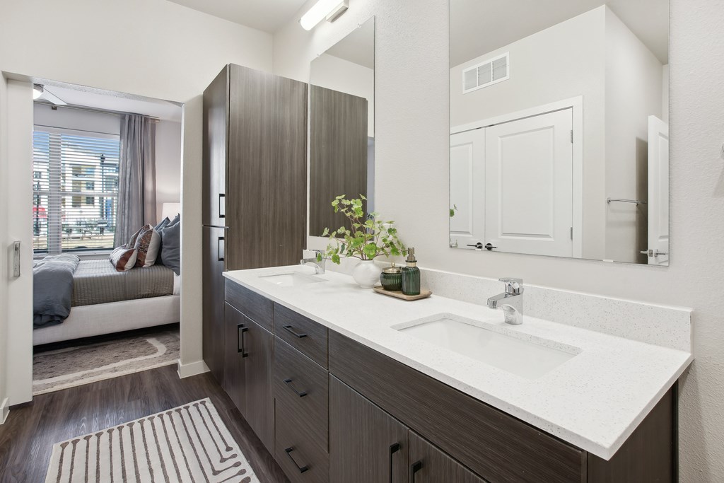 a bathroom with two sinks and a mirror in an apartment