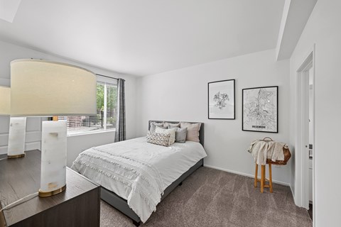 A bedroom with a large bed and two framed pictures on the wall.