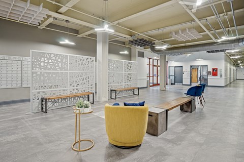 A modern office space with a yellow chair and a table with a plant on it.