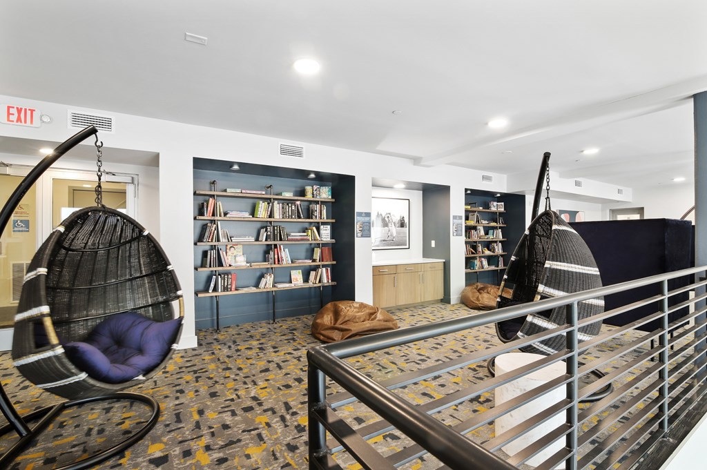 a living room with two hanging hammock chairs and a library