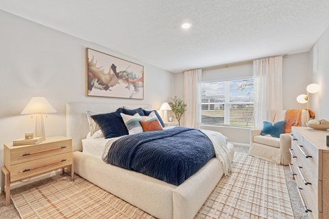 A bedroom with a large bed and a painting on the wall.