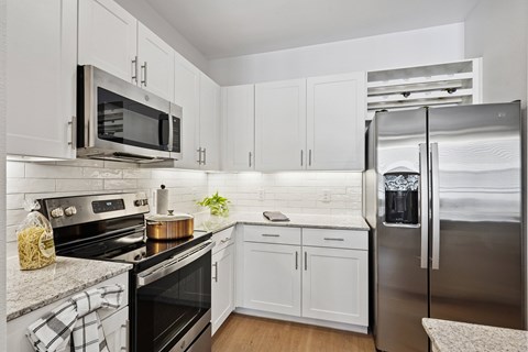 A kitchen with white cabinets and a black stove top.