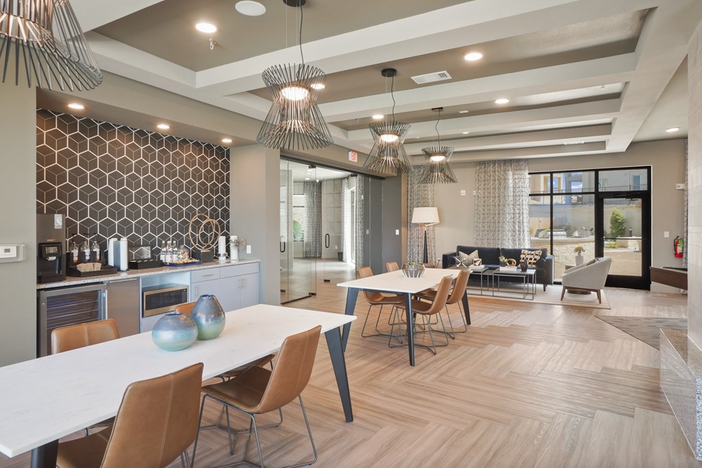 a resident clubhouse with tables and chairs and a kitchenette