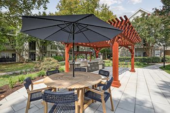a patio with a table and chairs and umbrellas