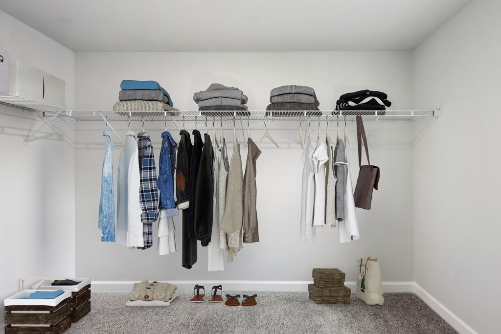 a closet with clothes hanging on a rack and shoes on the floor