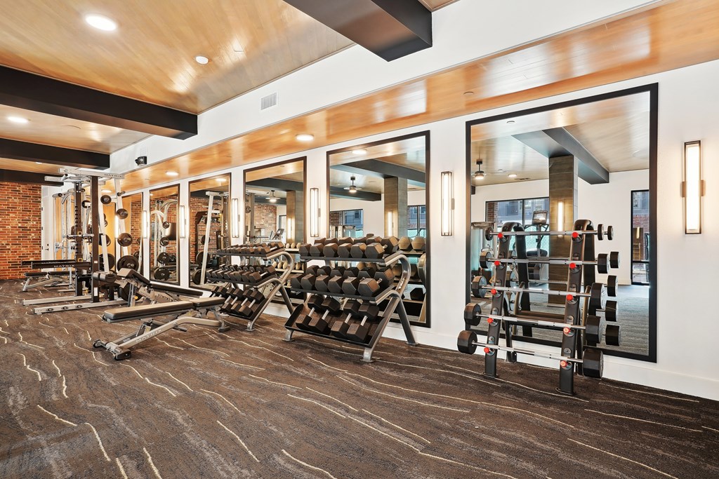a gym with cardio machines and weights on the floor