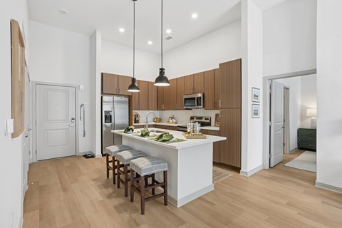 A kitchen with wooden cabinets and a white island.