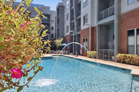 A pool with a fountain in the middle of it.