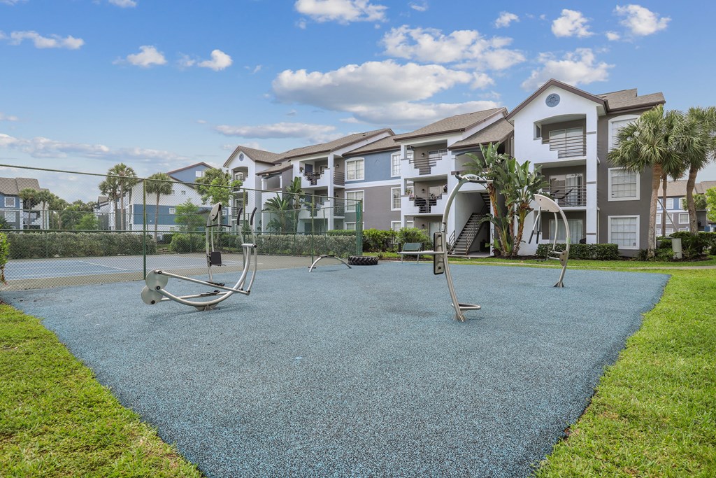 a playground with swing sets in front of an apartment building