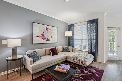 A living room with a couch, a table, and a painting on the wall.