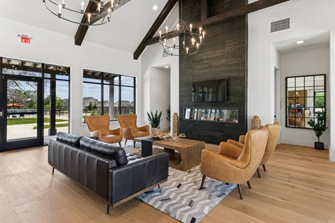 A living room with a black couch and a fireplace.