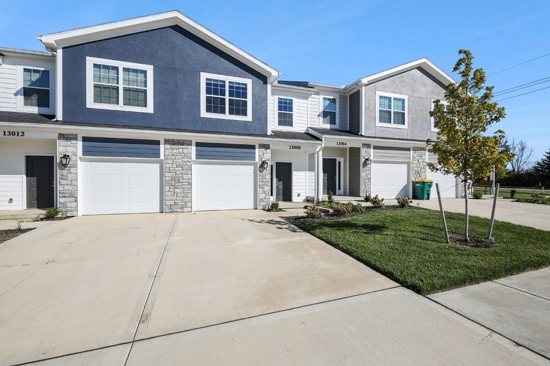 A two-story house with a garage and a driveway.