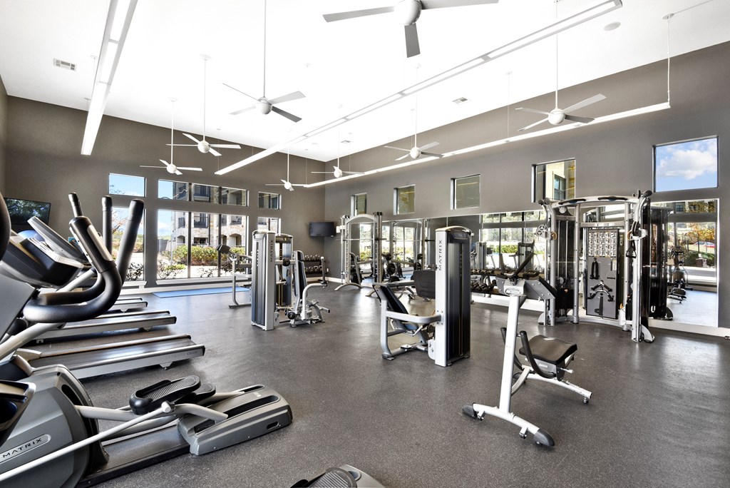 a gym with weights and other exercise equipment and windows