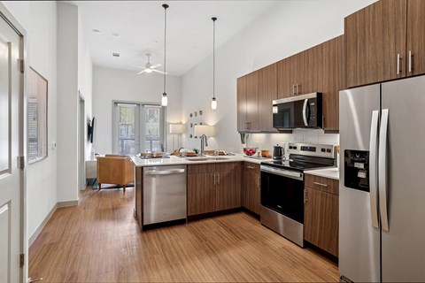 A modern kitchen with wooden cabinets and stainless steel appliances.
