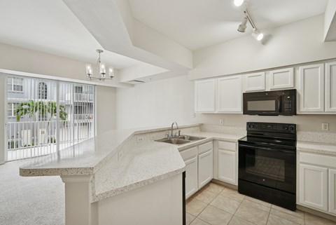 A kitchen with white cabinets and a black oven.