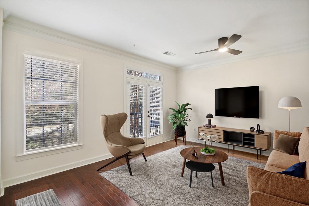 a living room with a couch and chairs and a tv