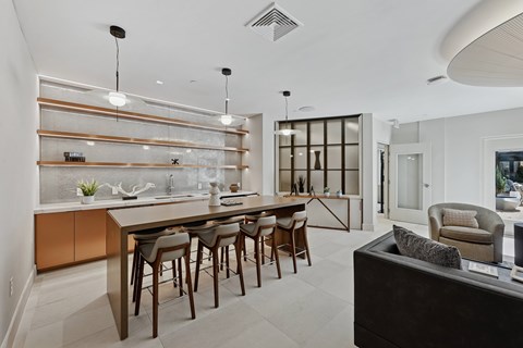 A modern kitchen with a long table and chairs.